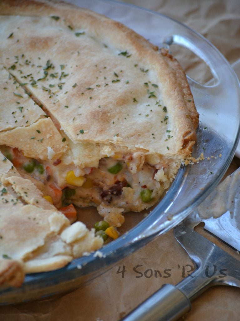 Seafood Pot Pie in a glass dish on brown parchment paper with a slice removed