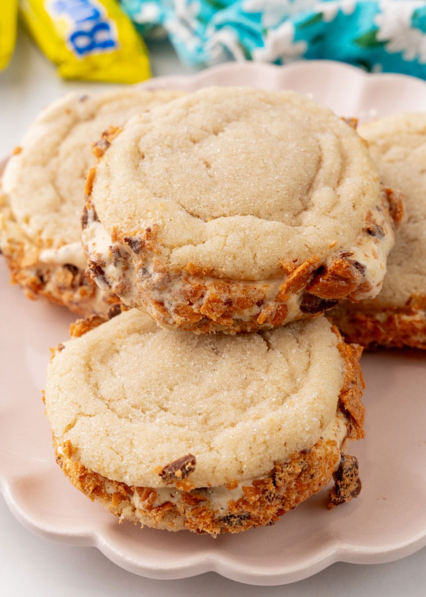 homemade butterfinger ice cream sandwich cookies stacked on a white serving plate