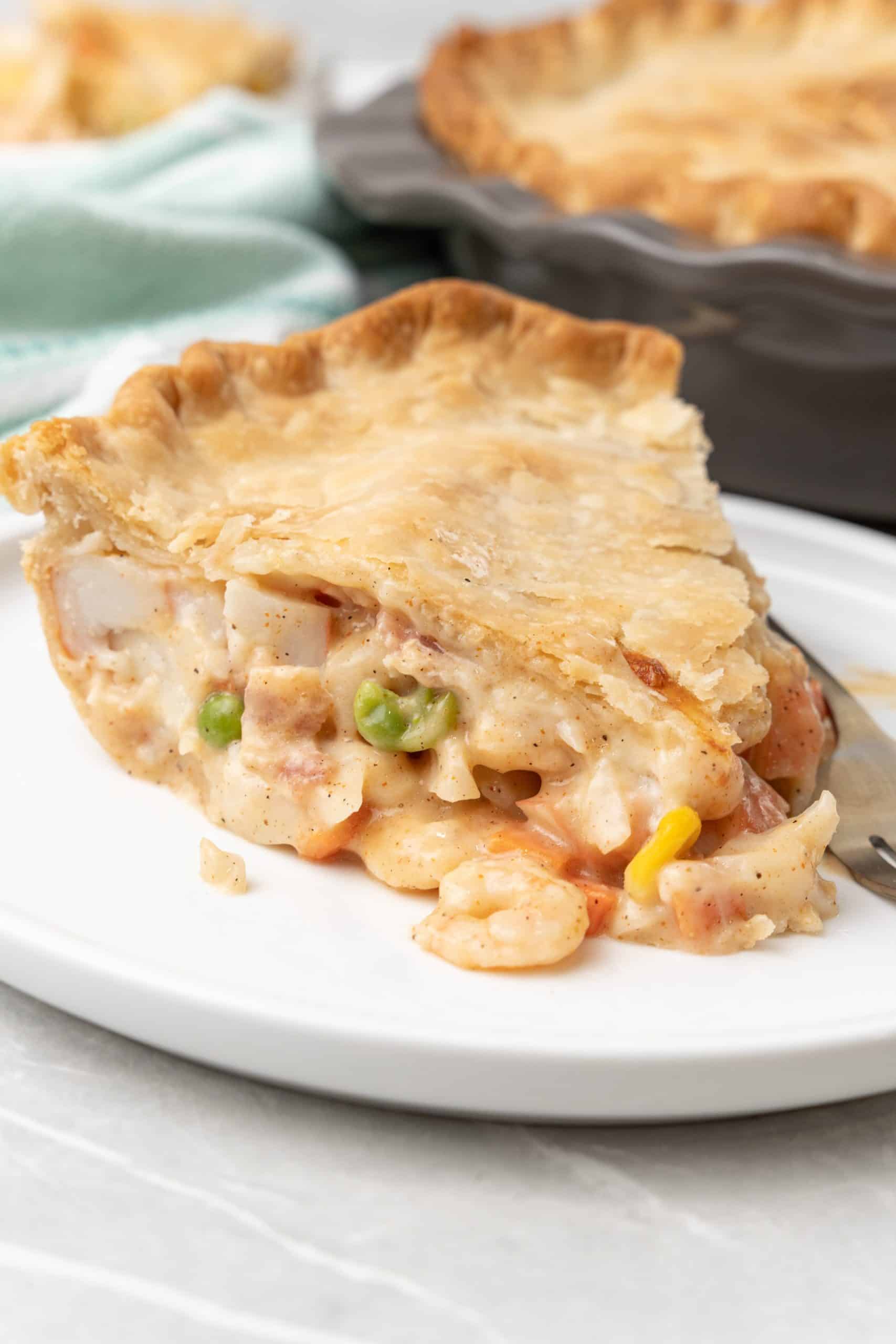a slice of seafood pot pie on a white dinner plate