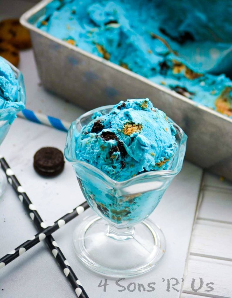 Cookie Monster Ice Cream served in glass sundae dishes with colorful straws and mini oreo and mini chocolate chip cookies in the background