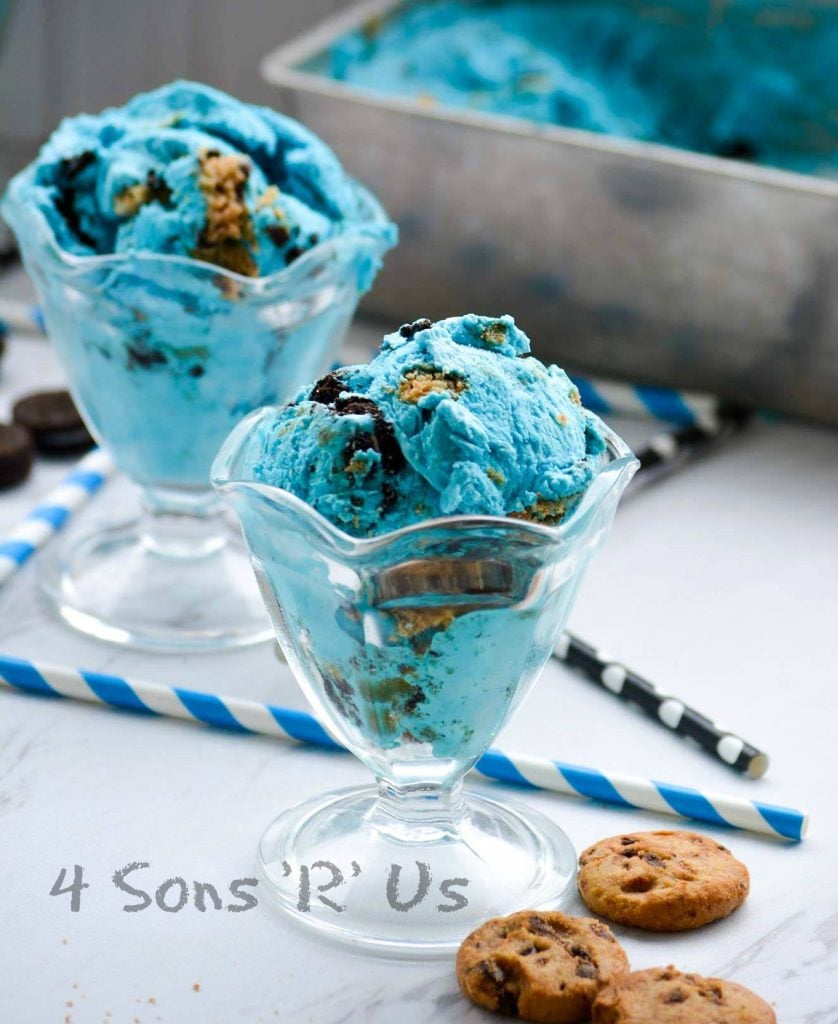 Cookie Monster Ice Cream served in glass sundae dishes with colorful straws and mini oreo and mini chocolate chip cookies in the background