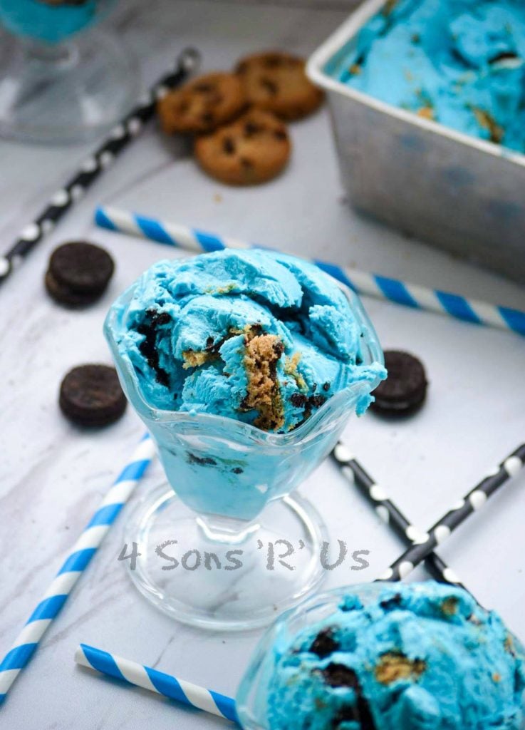 Cookie Monster Ice Cream served in glass sundae dishes with colorful straws and mini oreo and mini chocolate chip cookies in the background