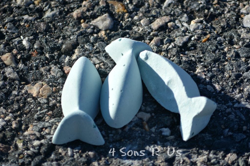 homemade purple sidewalk chalk laying on asphalt