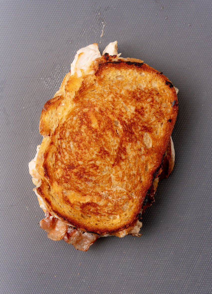 a grilled chipotle chicken bacon ranch panini sandwich on a gray countertop