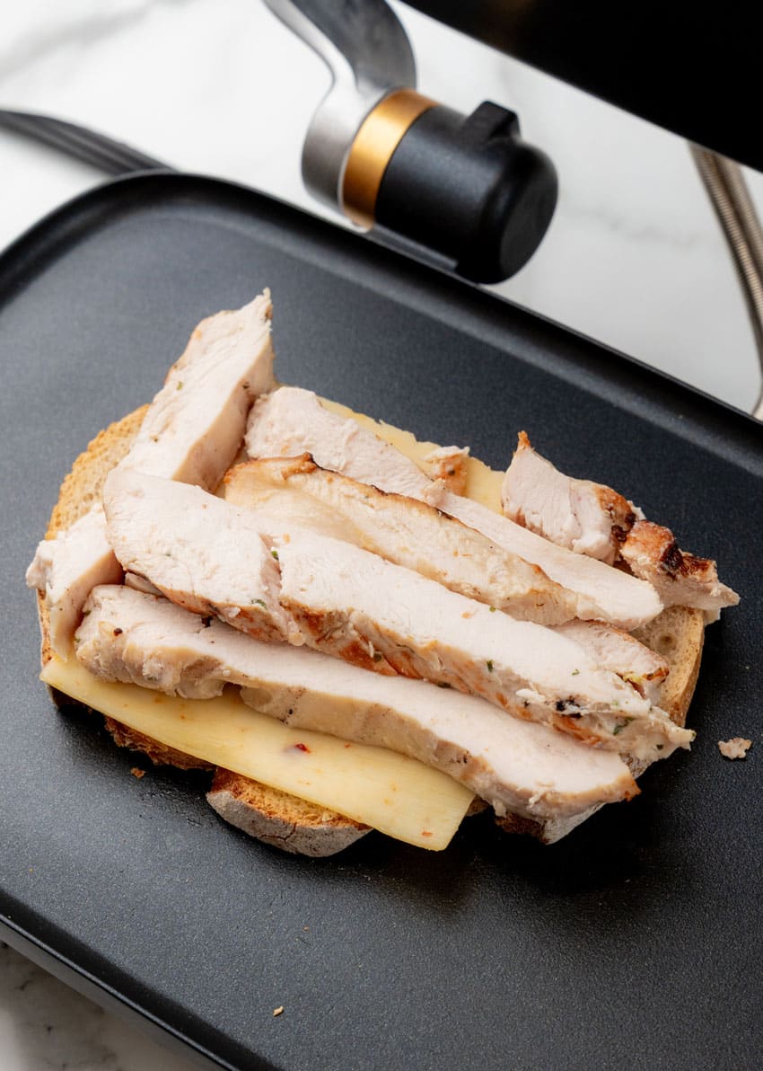 grilled chicken on thick slice of bread on a panini grill