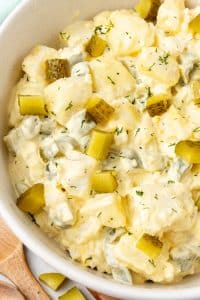 dill pickle potato salad in a large white mixing bowl