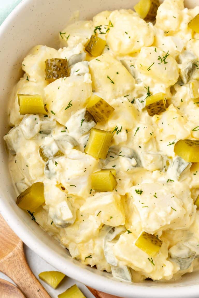 dill pickle potato salad in a large white mixing bowl