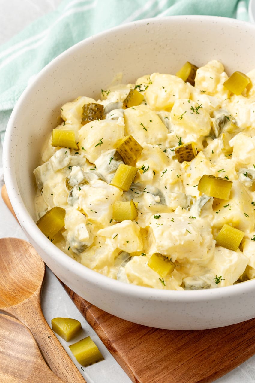dill pickle potato salad in a large white mixing bowl