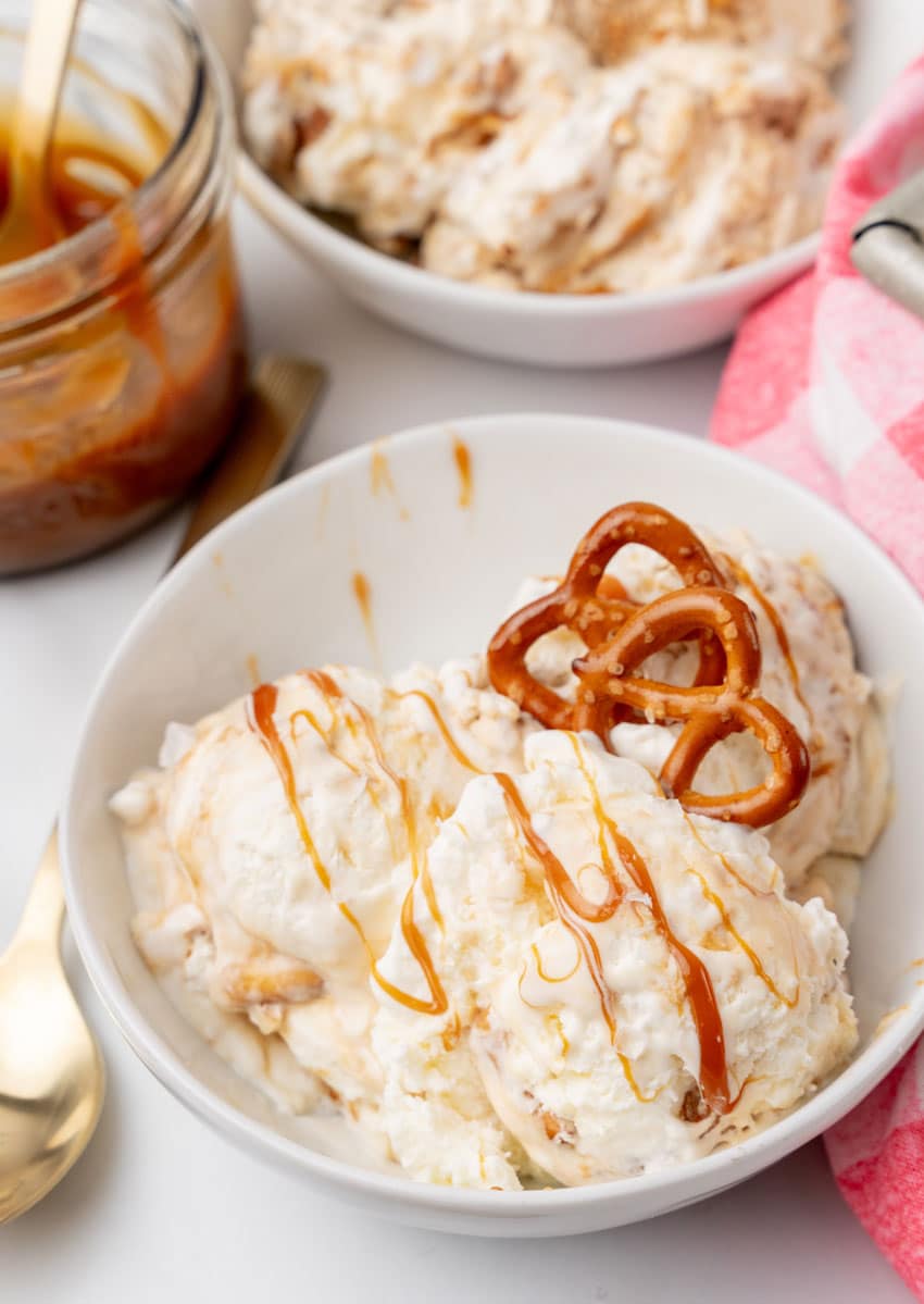scoops of salted caramel pretzel ice cream in a white bowl