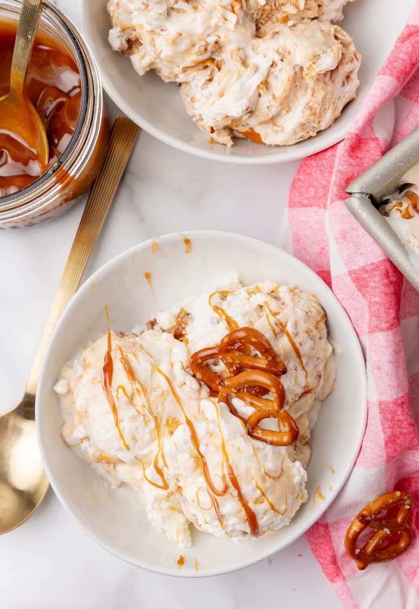 scoops of salted caramel pretzel ice cream in a white bowl