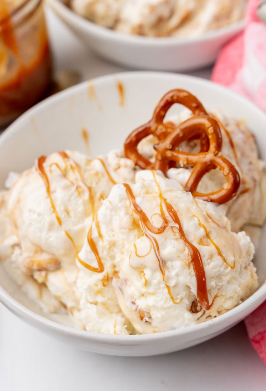 scoops of salted caramel pretzel ice cream in a white bowl