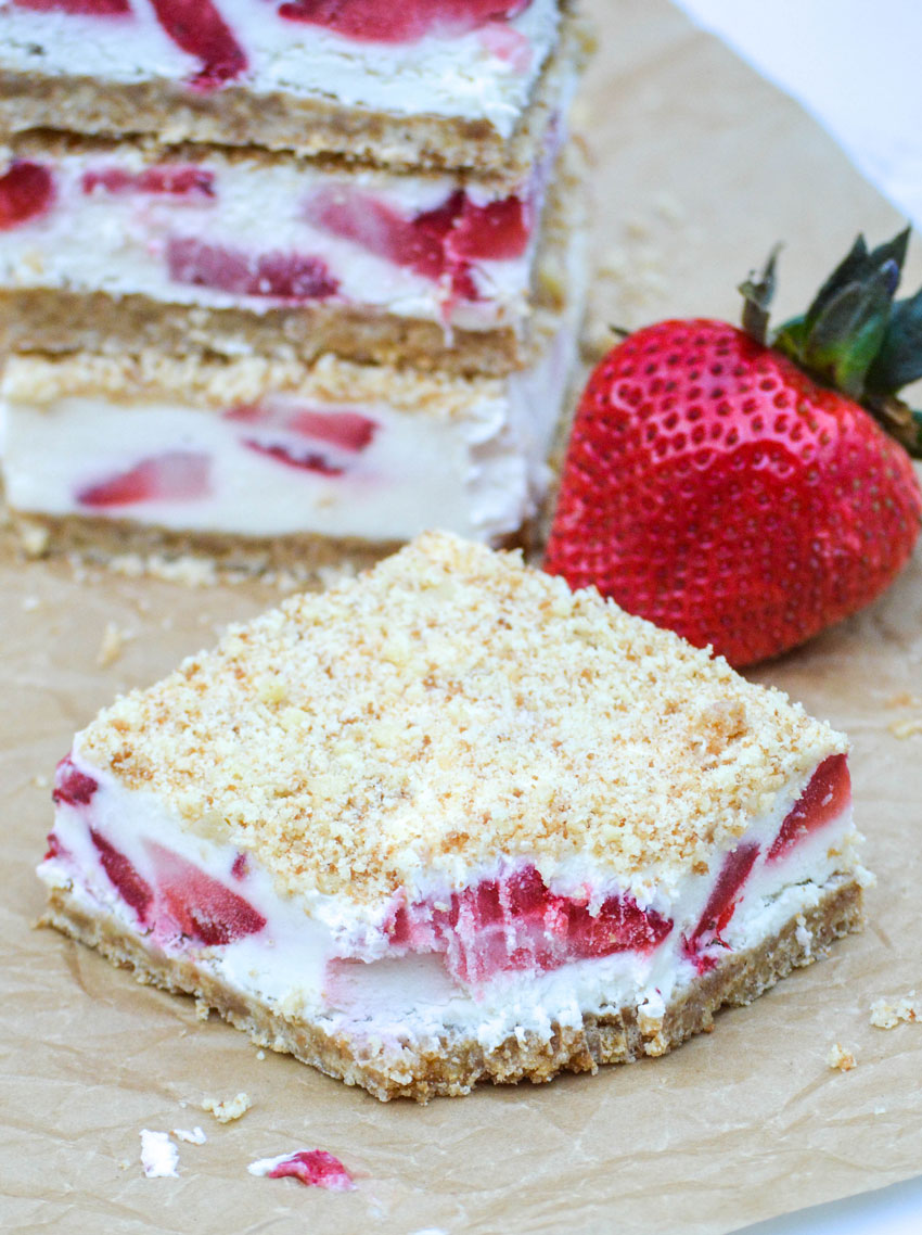 strawberry crunch bars cut into squares on a sheet of brown parchment paper