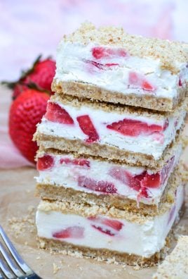 three strawberry crunch bars stacked on a piece of brown parchment paper