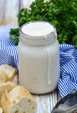 alabama white barbecue sauce in a glass mason jar with some dripping down the side