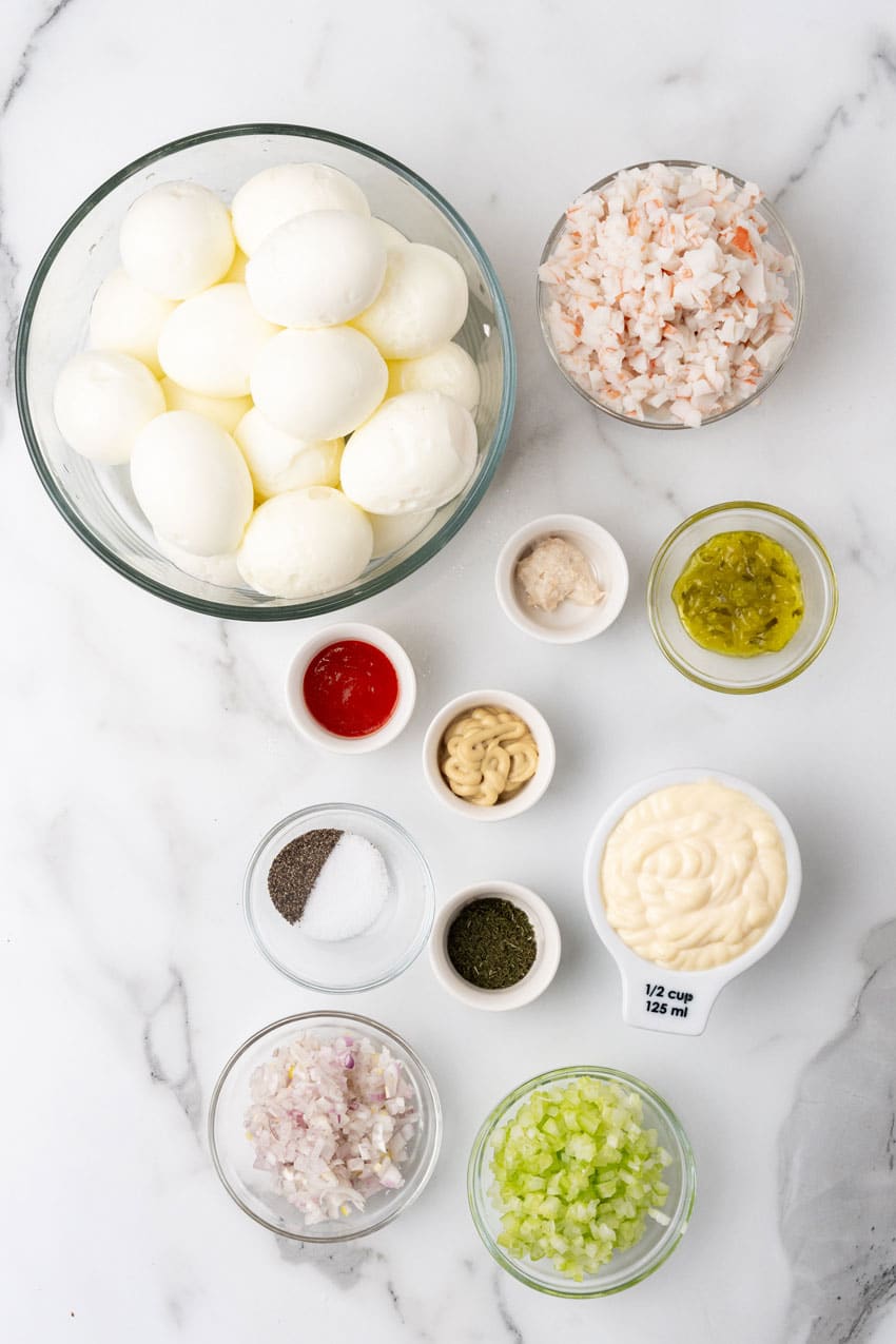 an overhead image showing the measured ingredients needed to make a batch of creamy crab stuffed deviled eggs