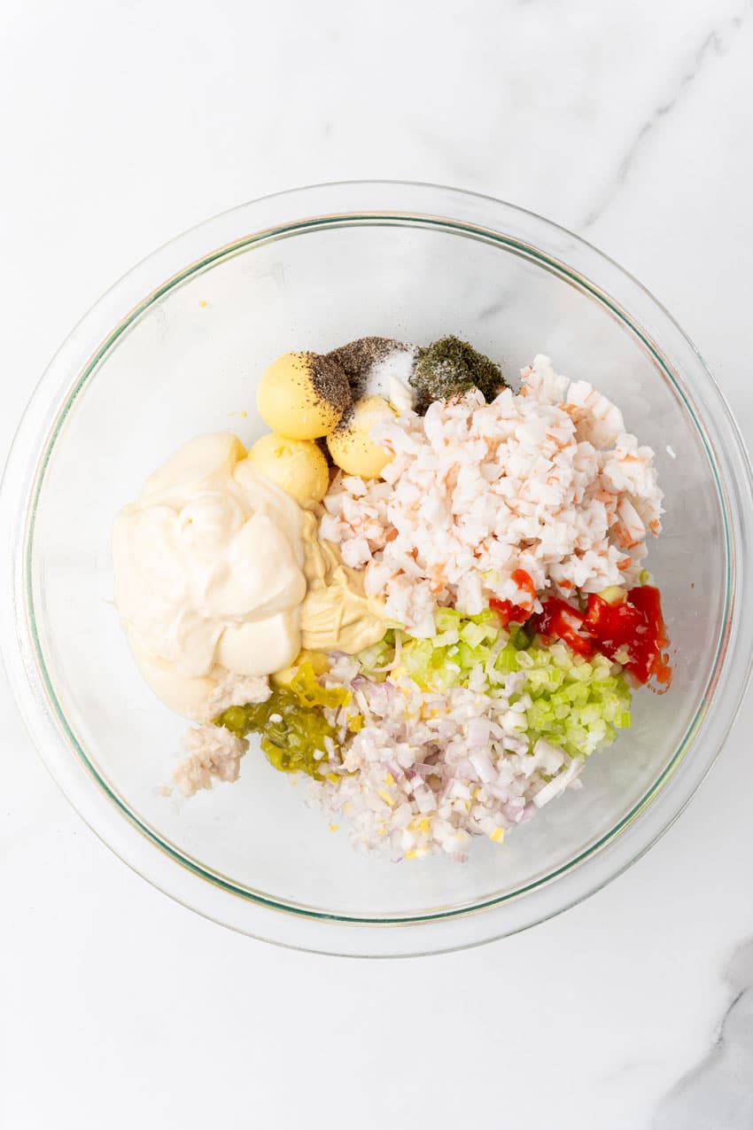 crab stuffed deviled egg filling ingredients in a glass mixing bowl