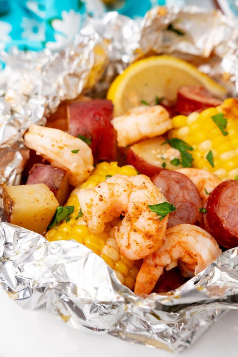 low country boil foil packets on a wooden cutting board