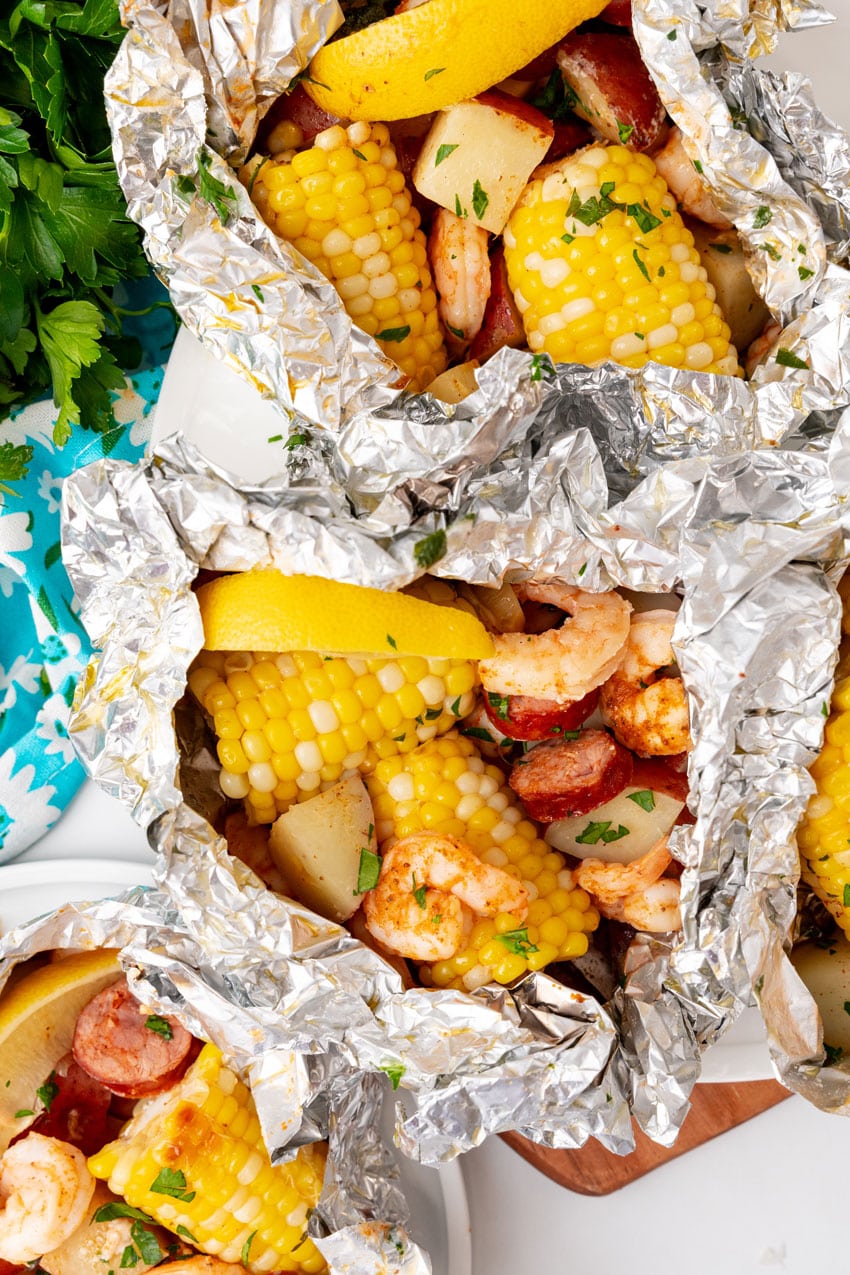 low country boil foil packets on a wooden cutting board