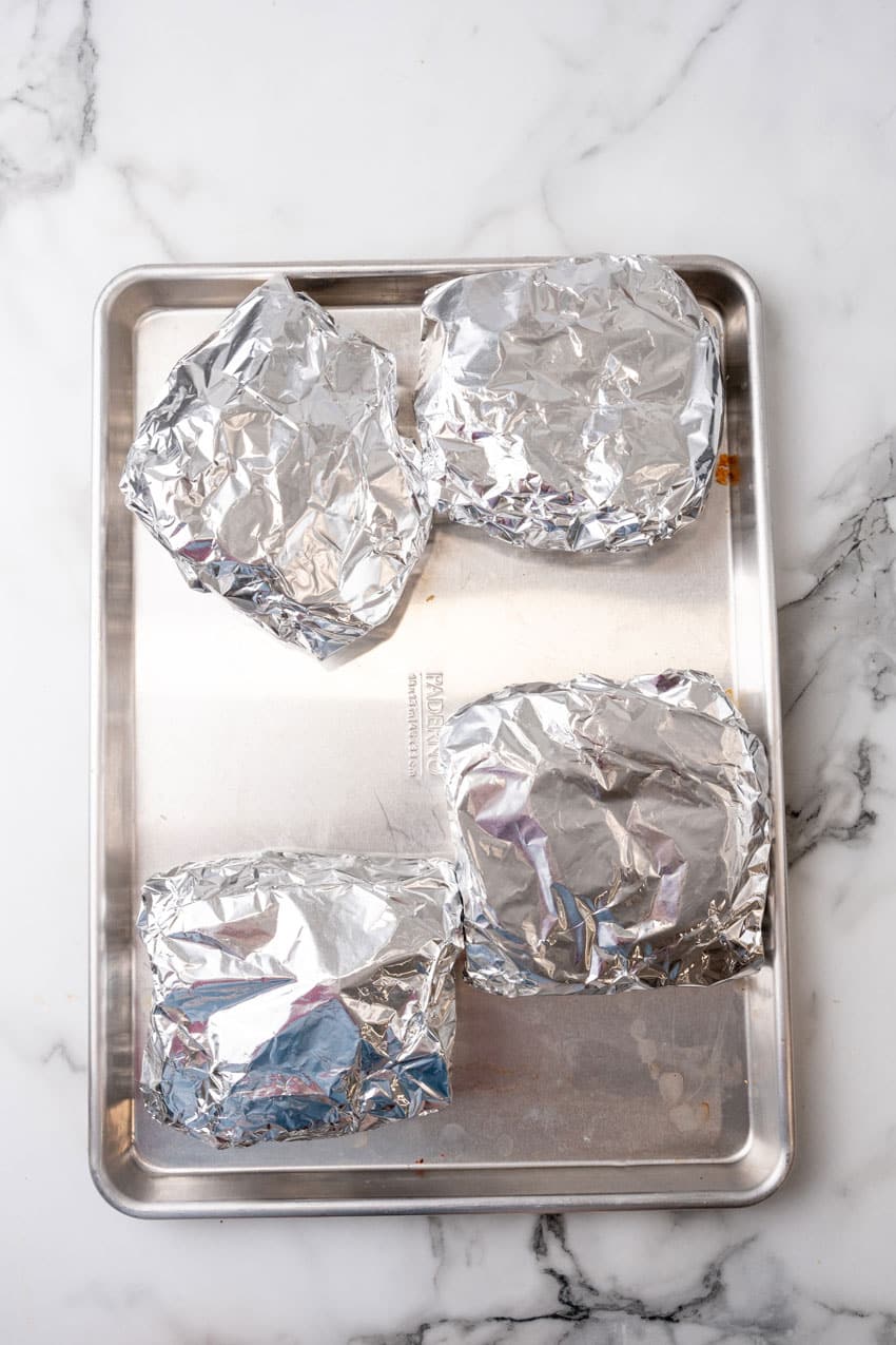 low country boil foil packets on a large metal baking sheet pan