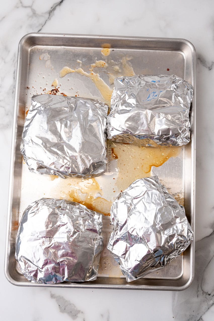 low country boil foil packets on a large metal baking sheet pan