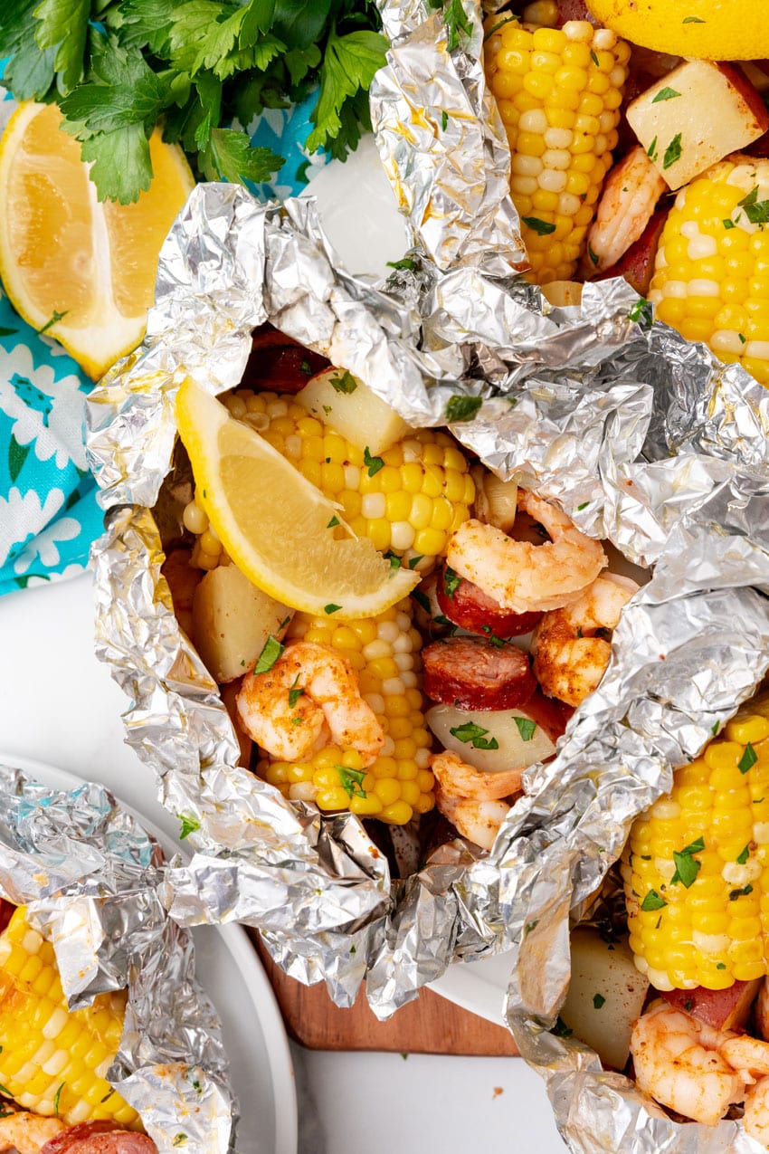 low country boil foil packets on a wooden cutting board