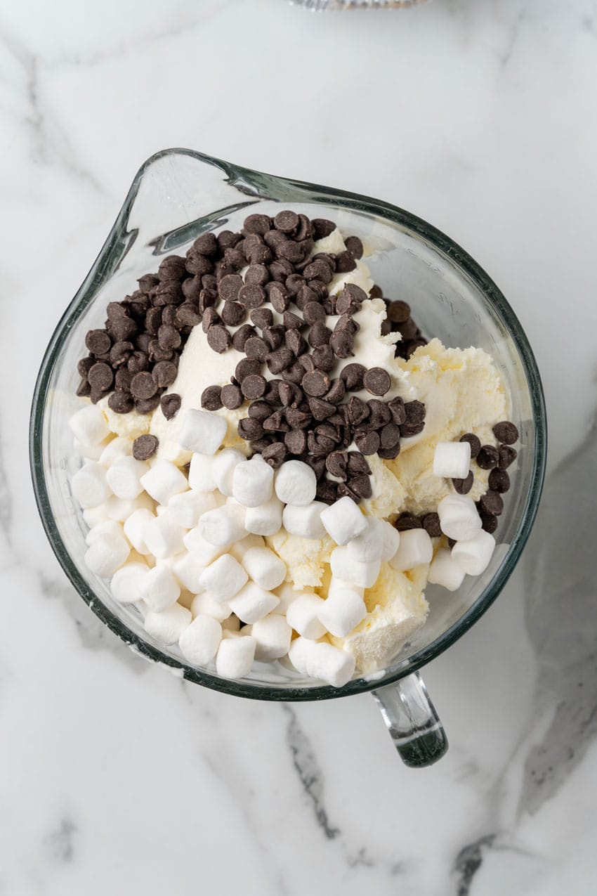 softened vanilla ice cream, chocolate chips, and mini marshmallows in a glass measuring cup