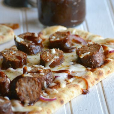 barbecue sausage flatbread pizza on a wooden table