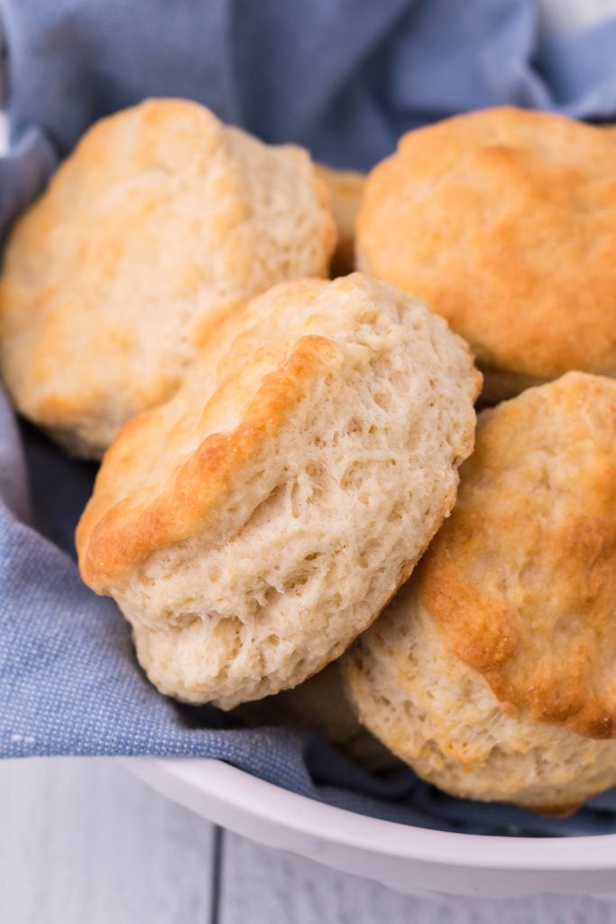 copycat KFC biscuits on a blue cloth in a white ceramic bread bowl