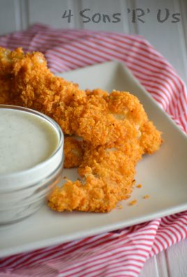 doritos crusted chicken fingers on a white plate with a small bowl of ranch dressing