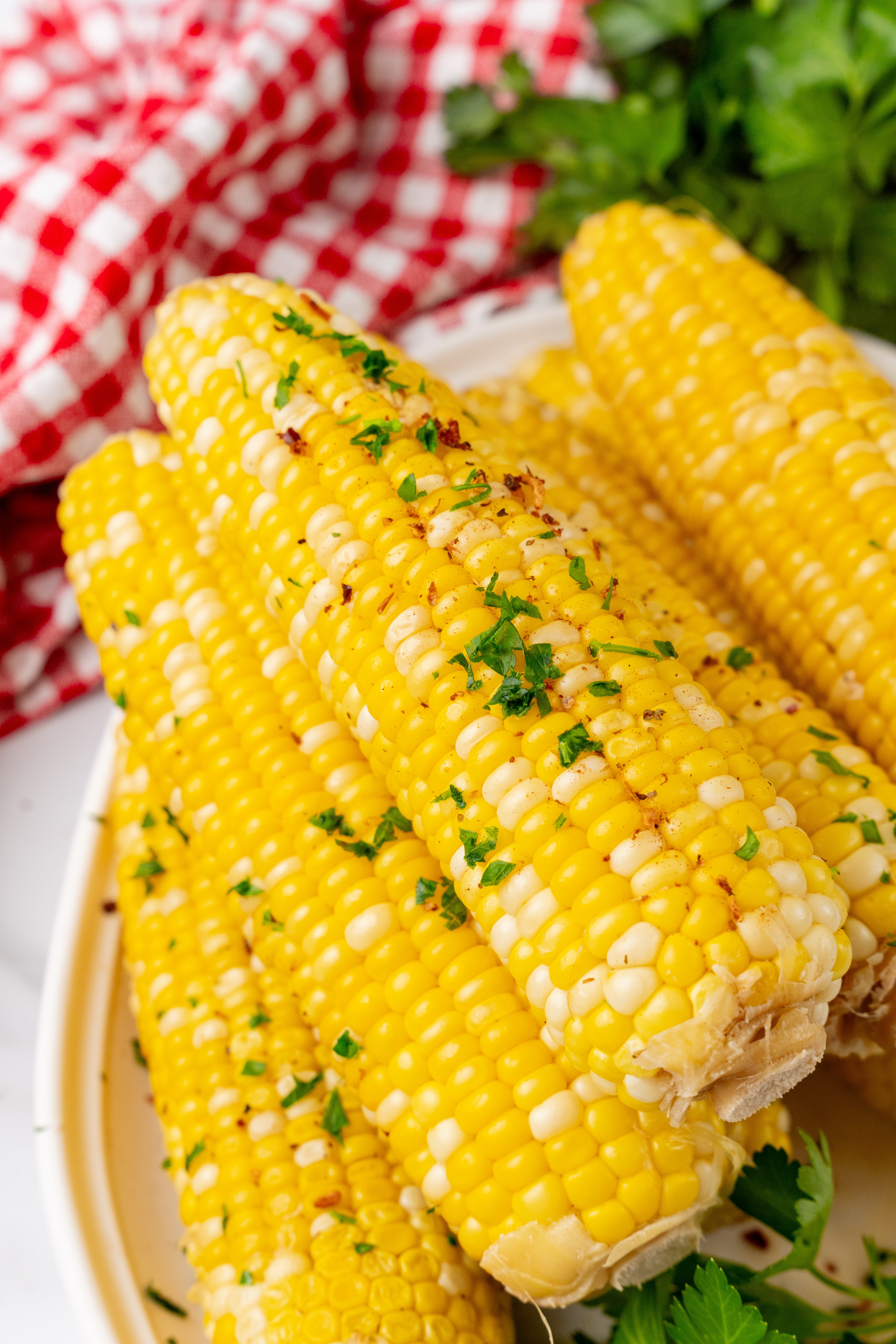 milk and honey corn on the cob piled on a white serving platter