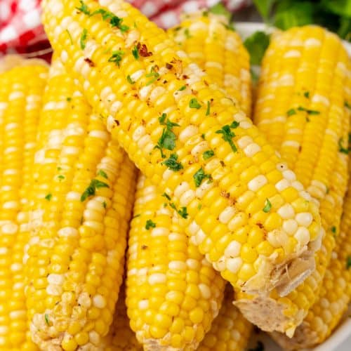 milk and honey corn on the cob piled on a white serving platter