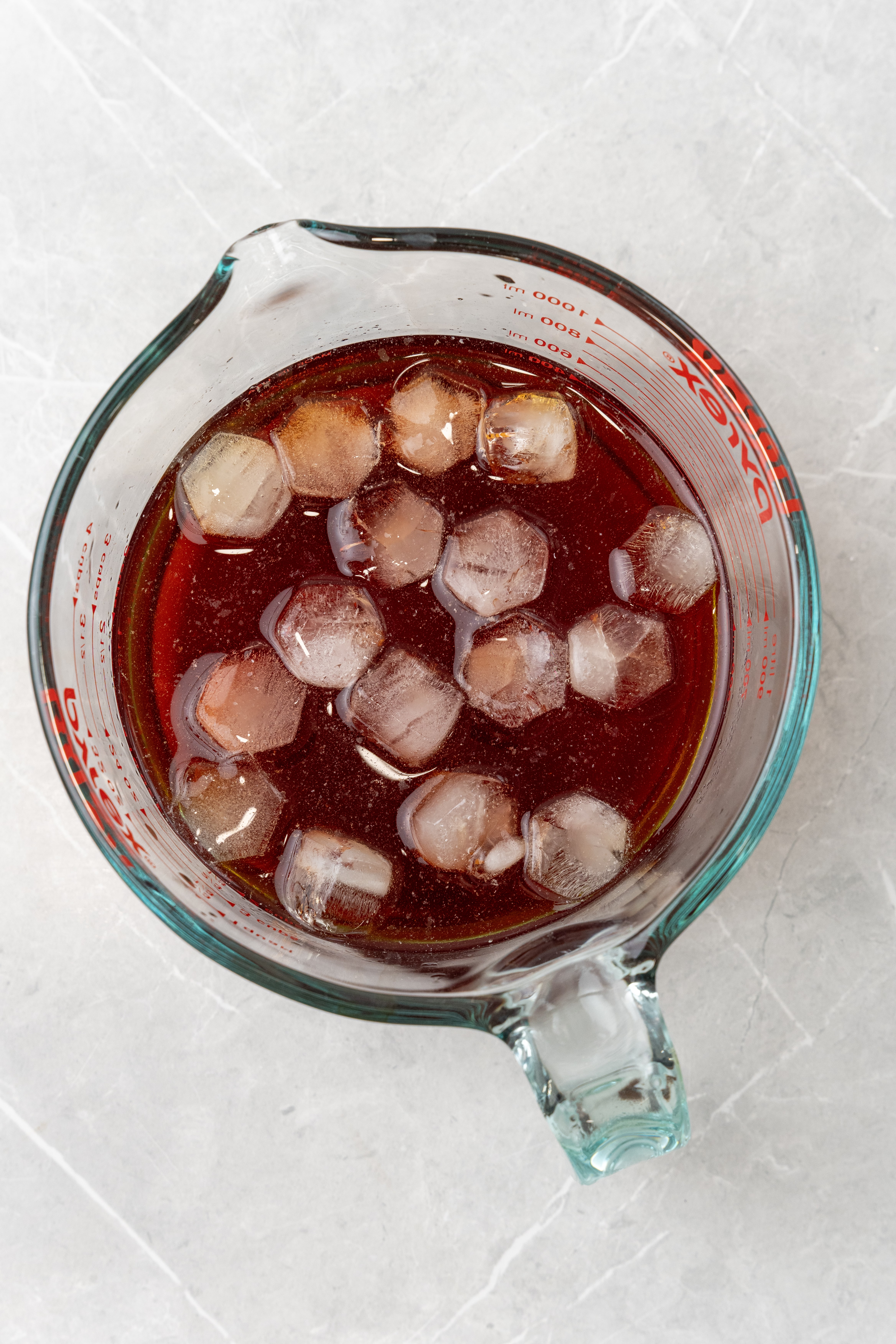 ice cubes in sweet tea in a glass measuring dish