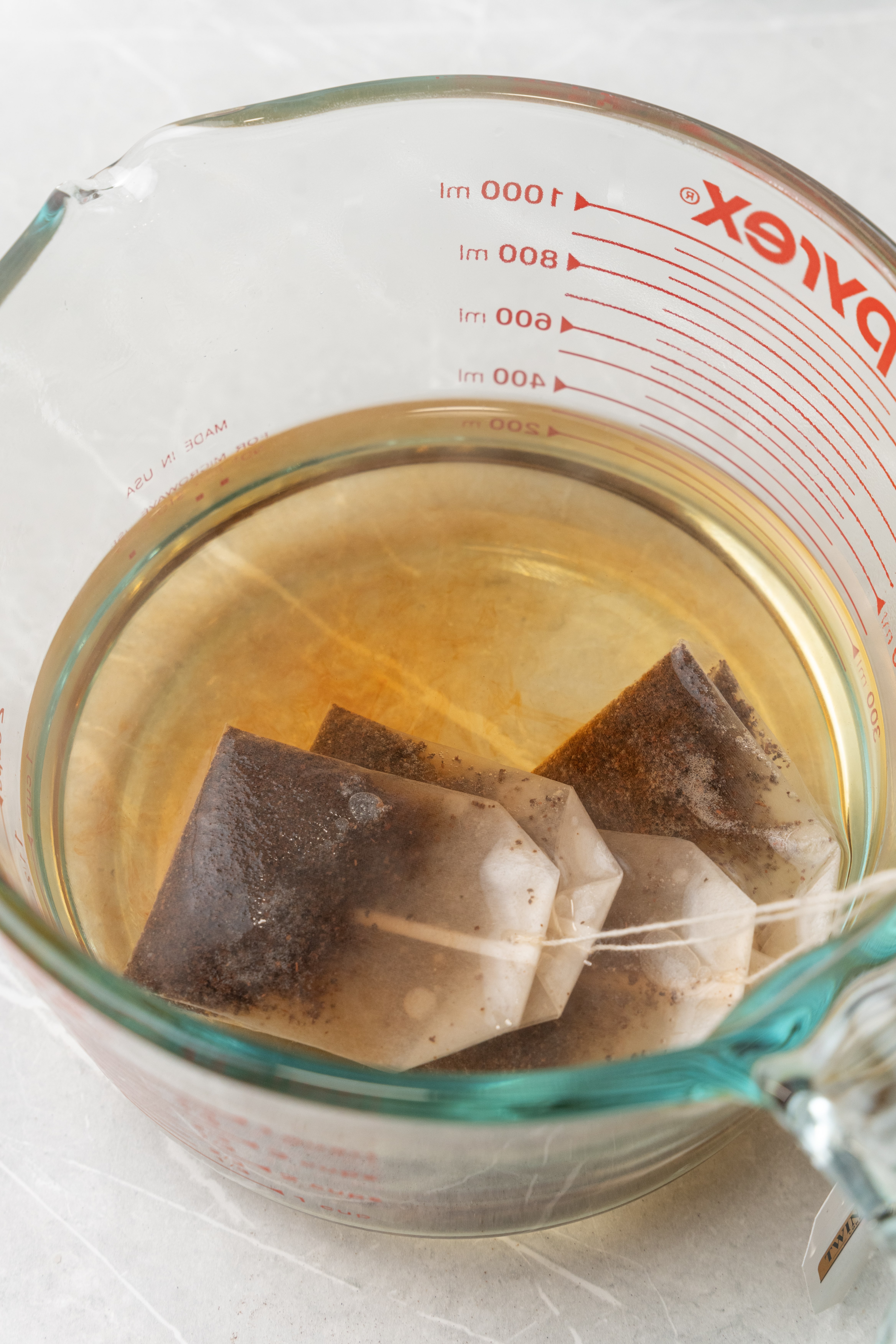tea bags steeping in water in a glass measuring dish