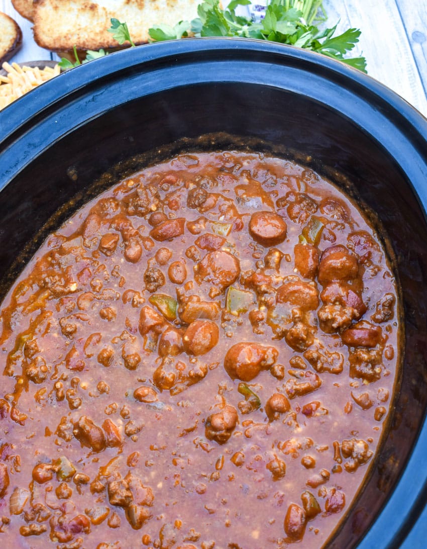 chili cheese dog chili in the black bowl of a slow cooker