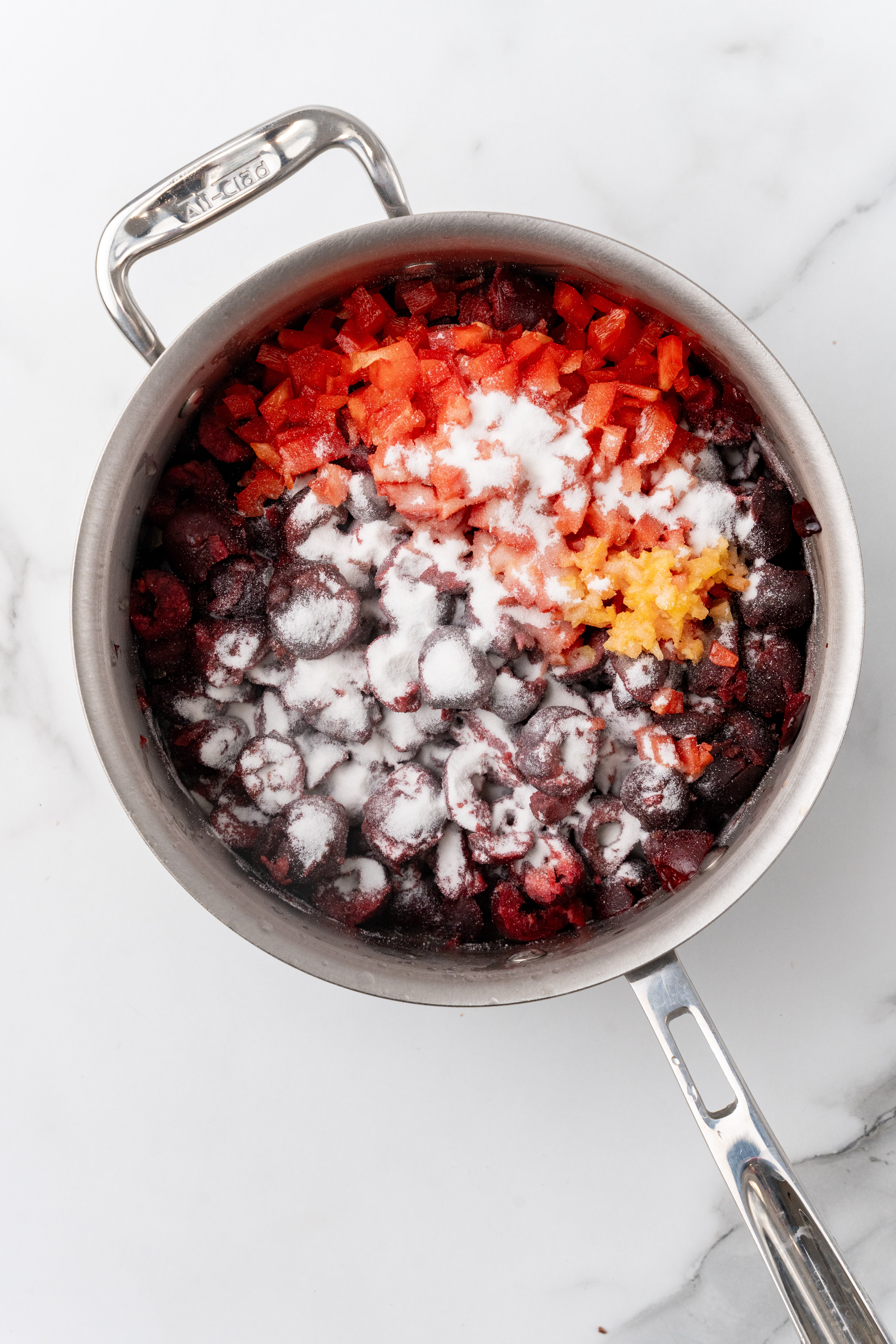 chopped cherries, onions, and peppers in a small metal pot