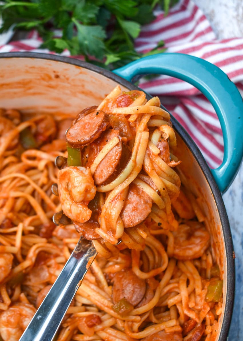 a silver spoon holding up a scoop of jambalaya pasta