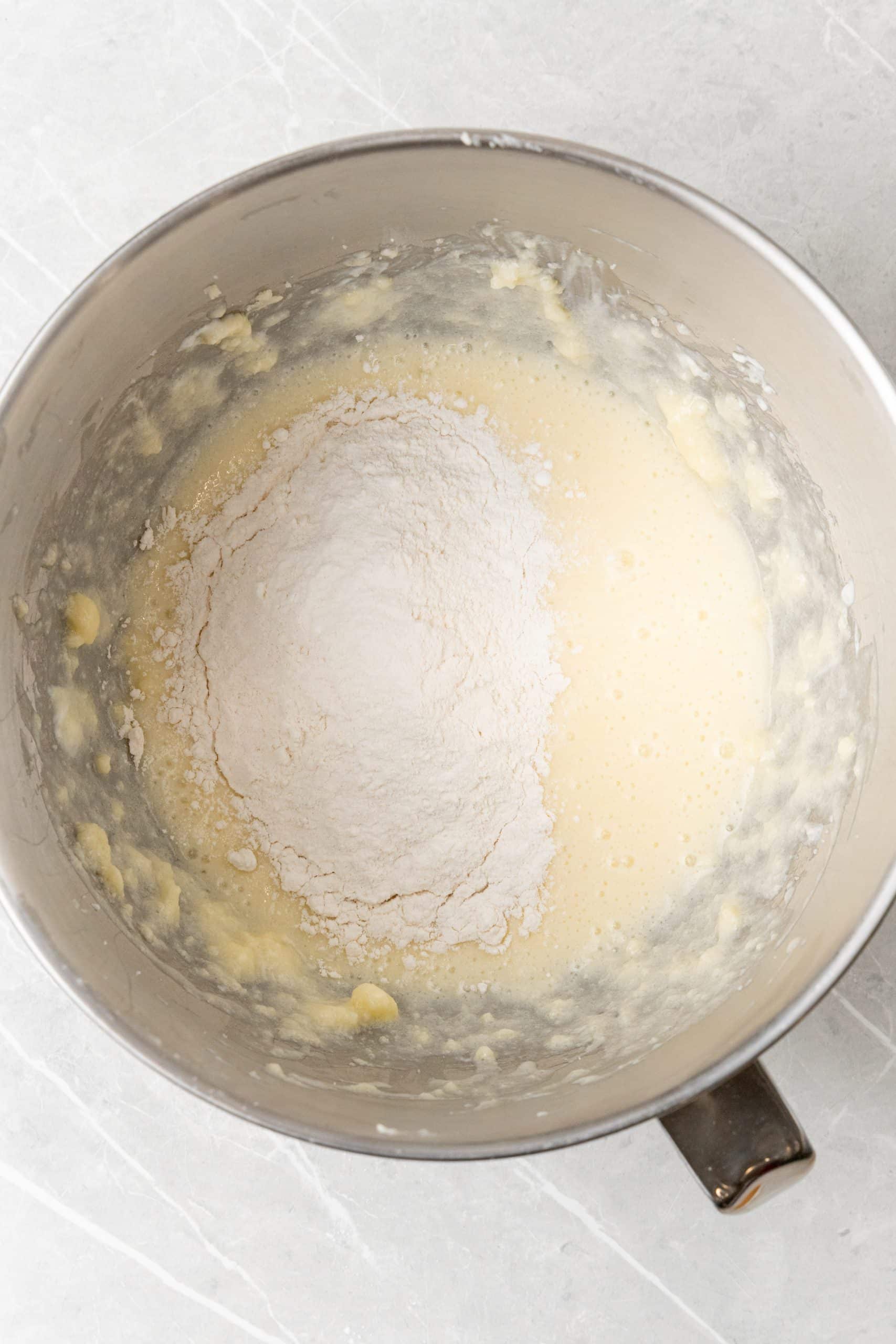 dry ingredients being added to wet for cupcakes in the bowl of a stand mixer