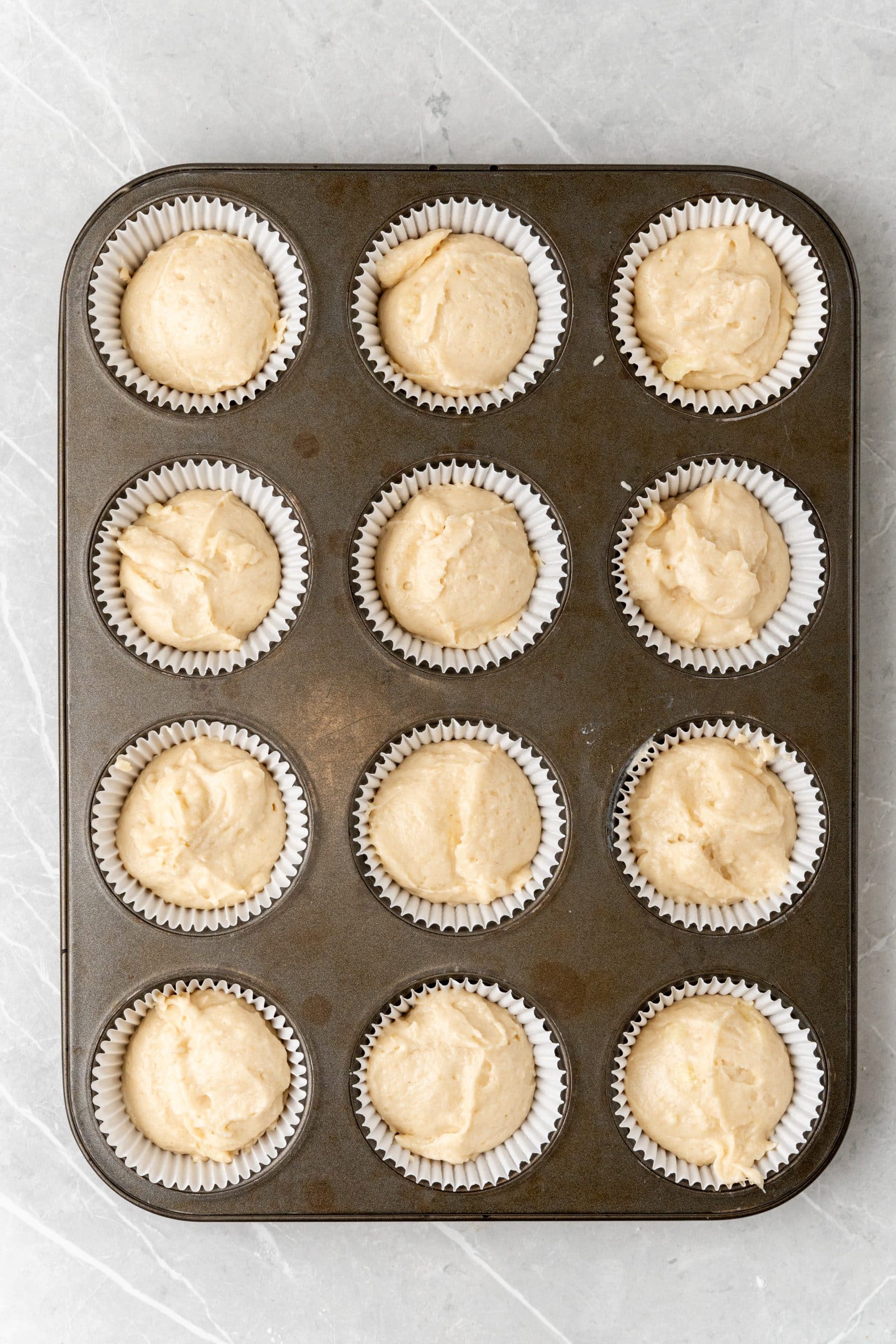 apple butter cupcake batter in cupcake liners in a muffin tin