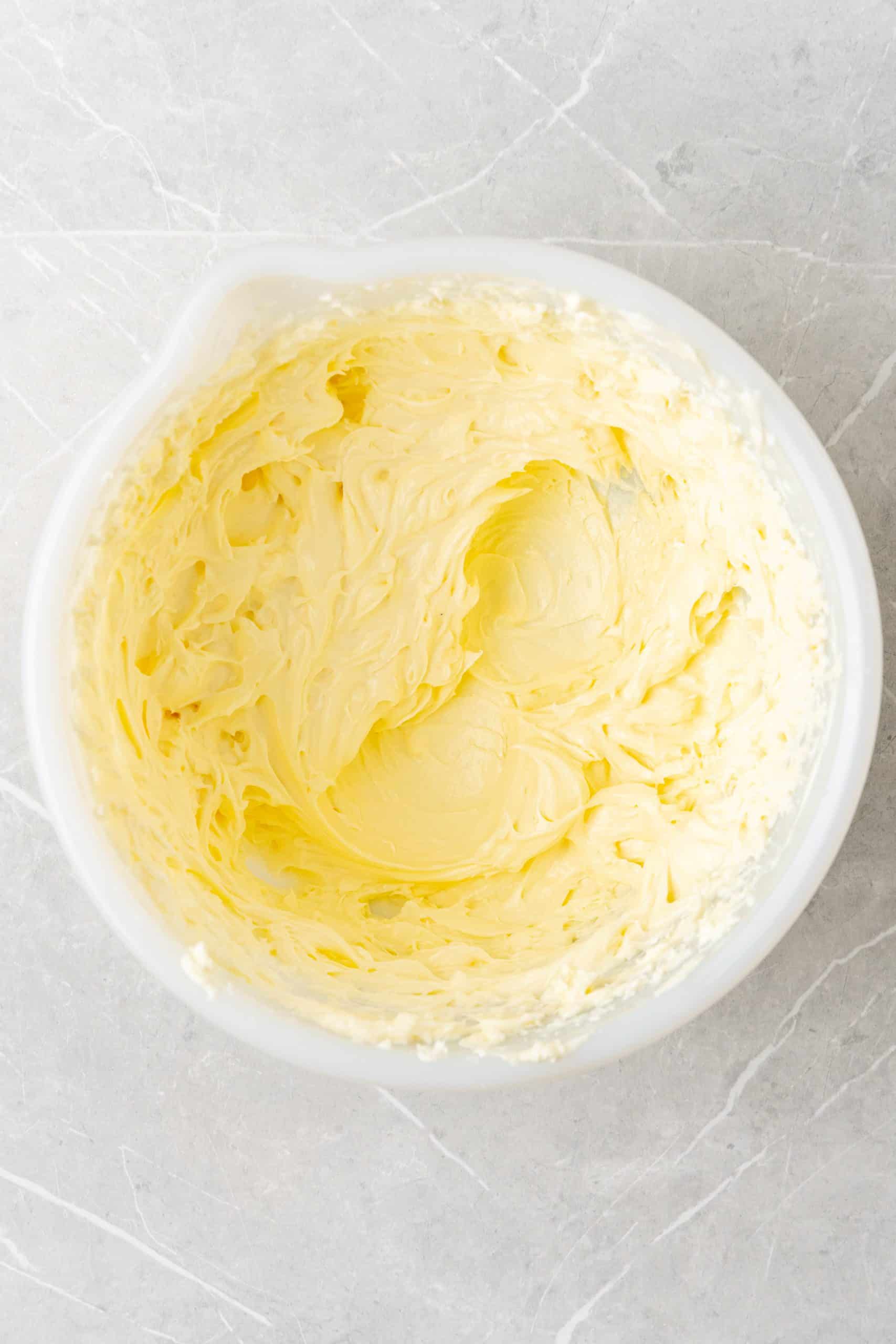 whipped cream cheese and butter in a white mixing bowl