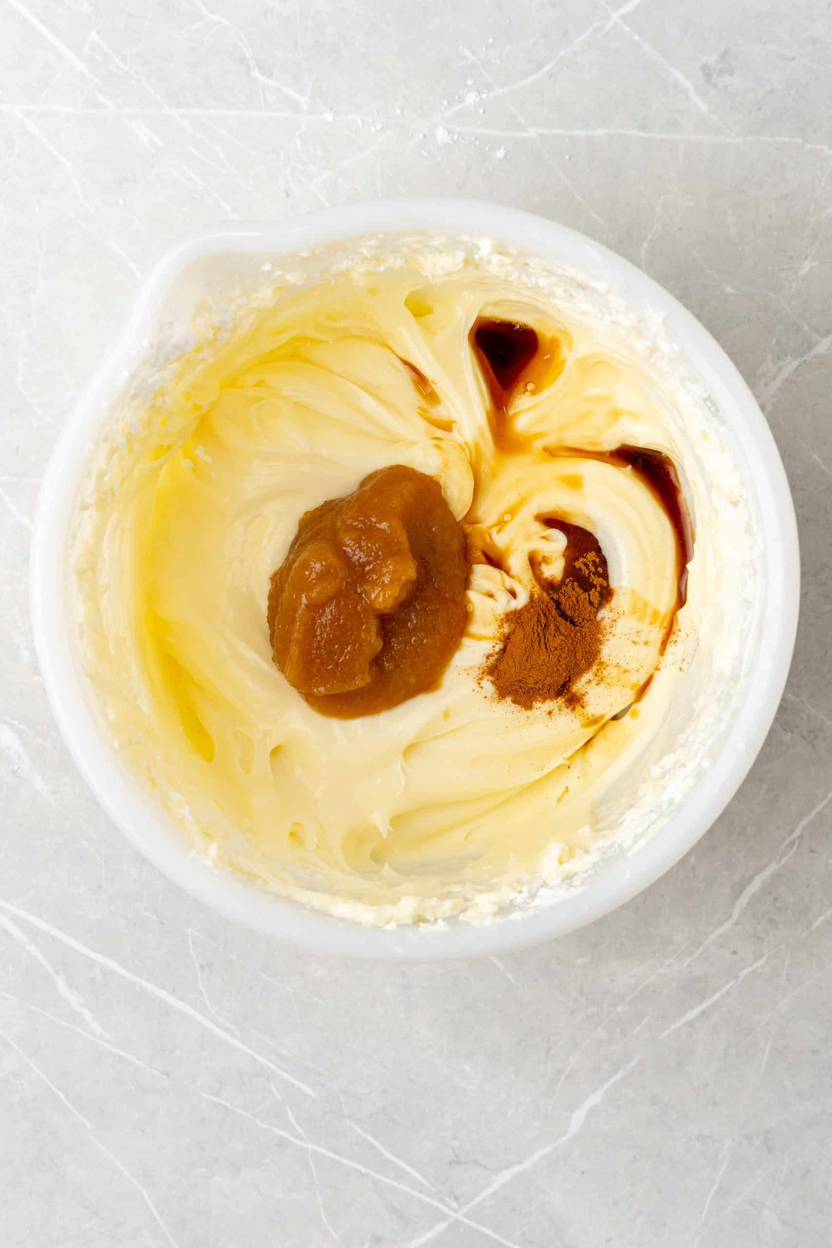 apple butter cream cheese frosting ingredients in a white mixing bowl
