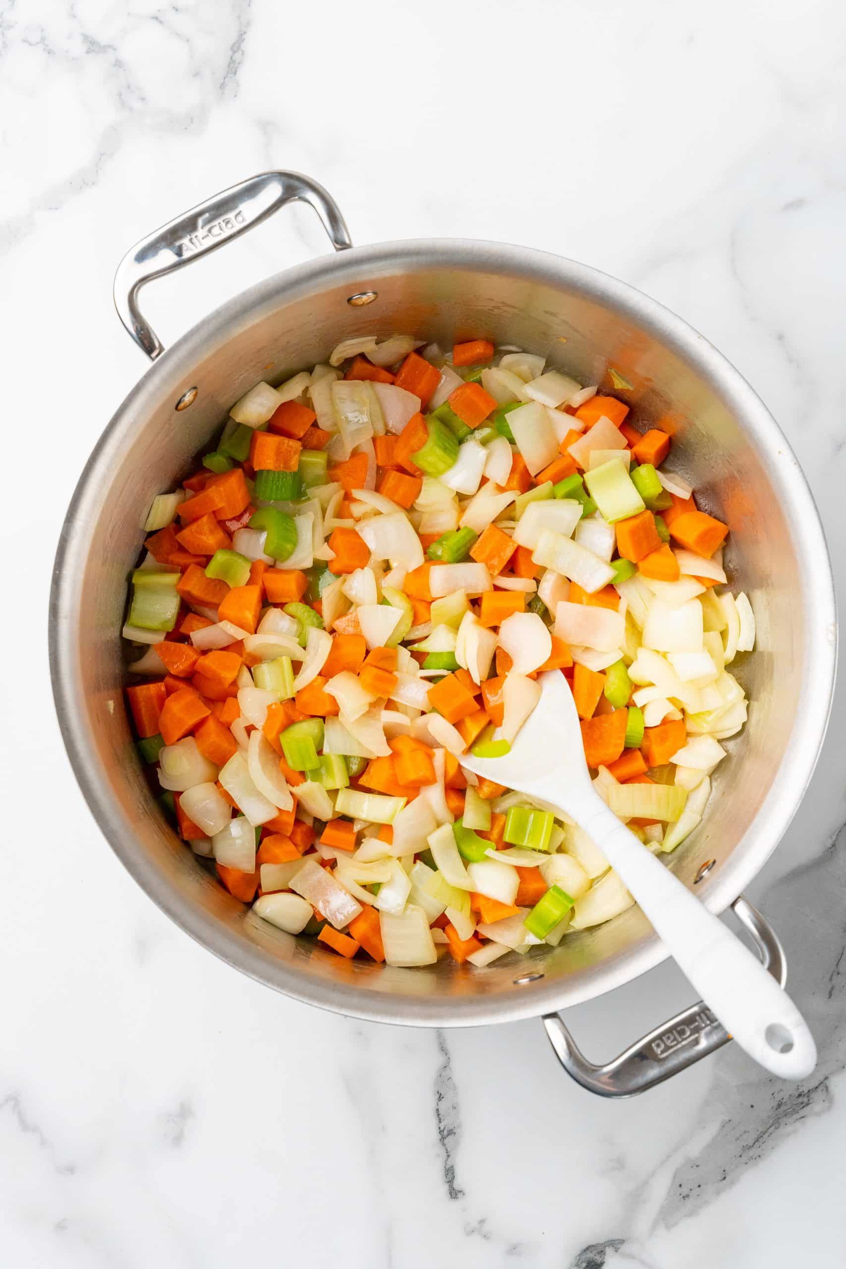 a sauteed mirepoix vegetable mix in a silver pot