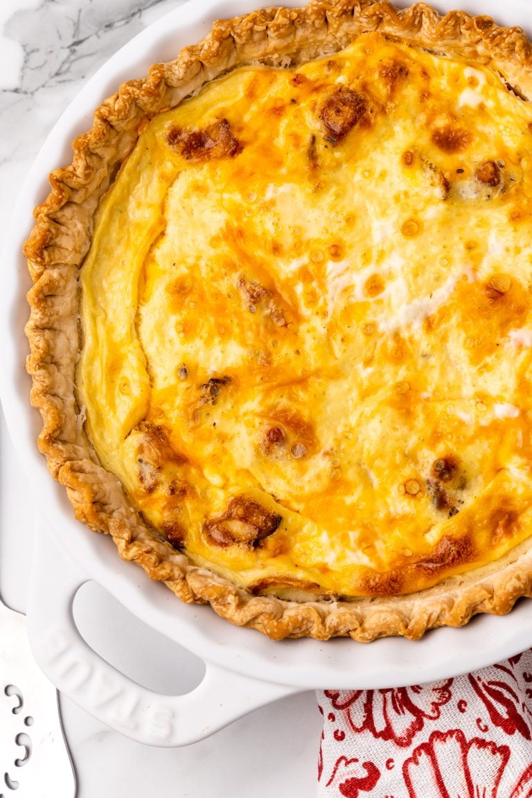 a cheddar bacon ranch quiche in a white pie dish