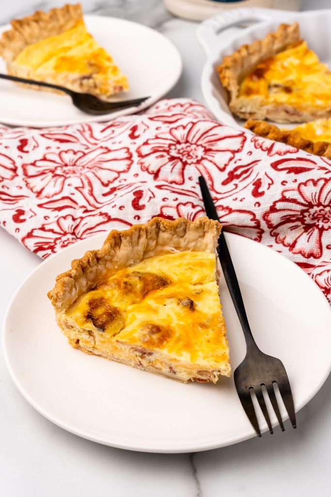 slices of crack quiche on small white plates with black forks