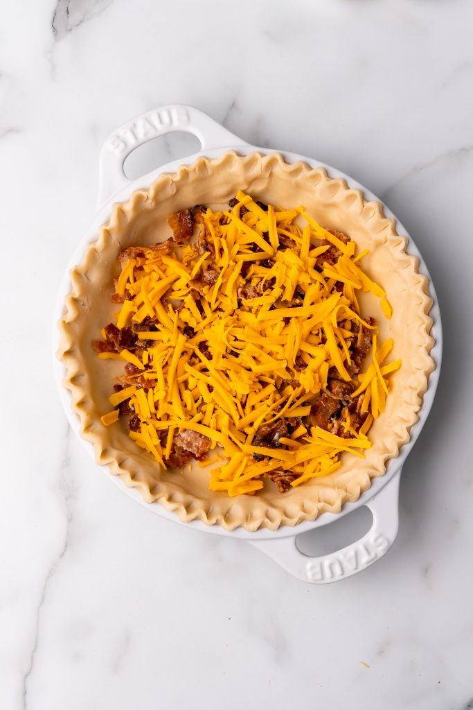 crisp crumbled bacon and shredded cheddar cheese in an unbaked pie shell