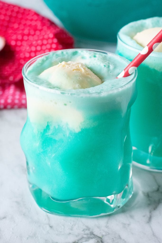 fizzy blue punch in a clear glass with a scoop of vanilla ice cream floating on top for stunning kid friendly ice cream float