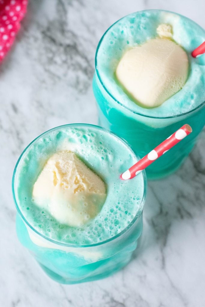 bright blue party punch has scoops of vanilla ice cream floating in it for a visual snowball effect