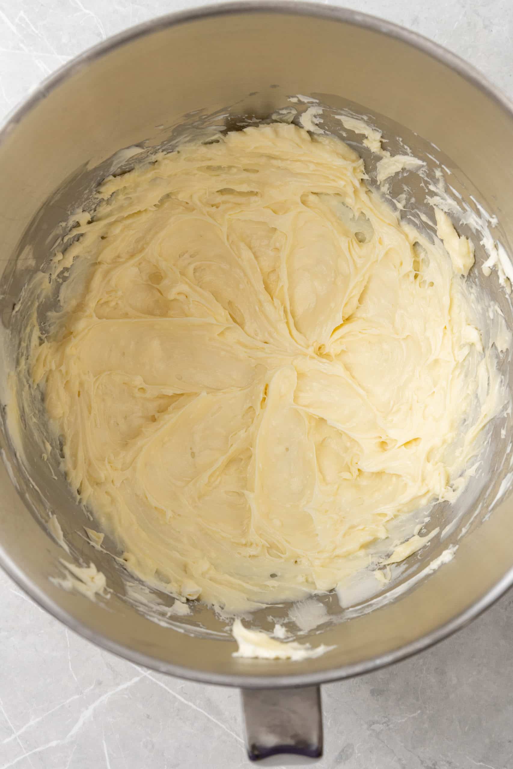 whipped butter and cream cheese for a buttercream frosting base in a metal mixing bowl