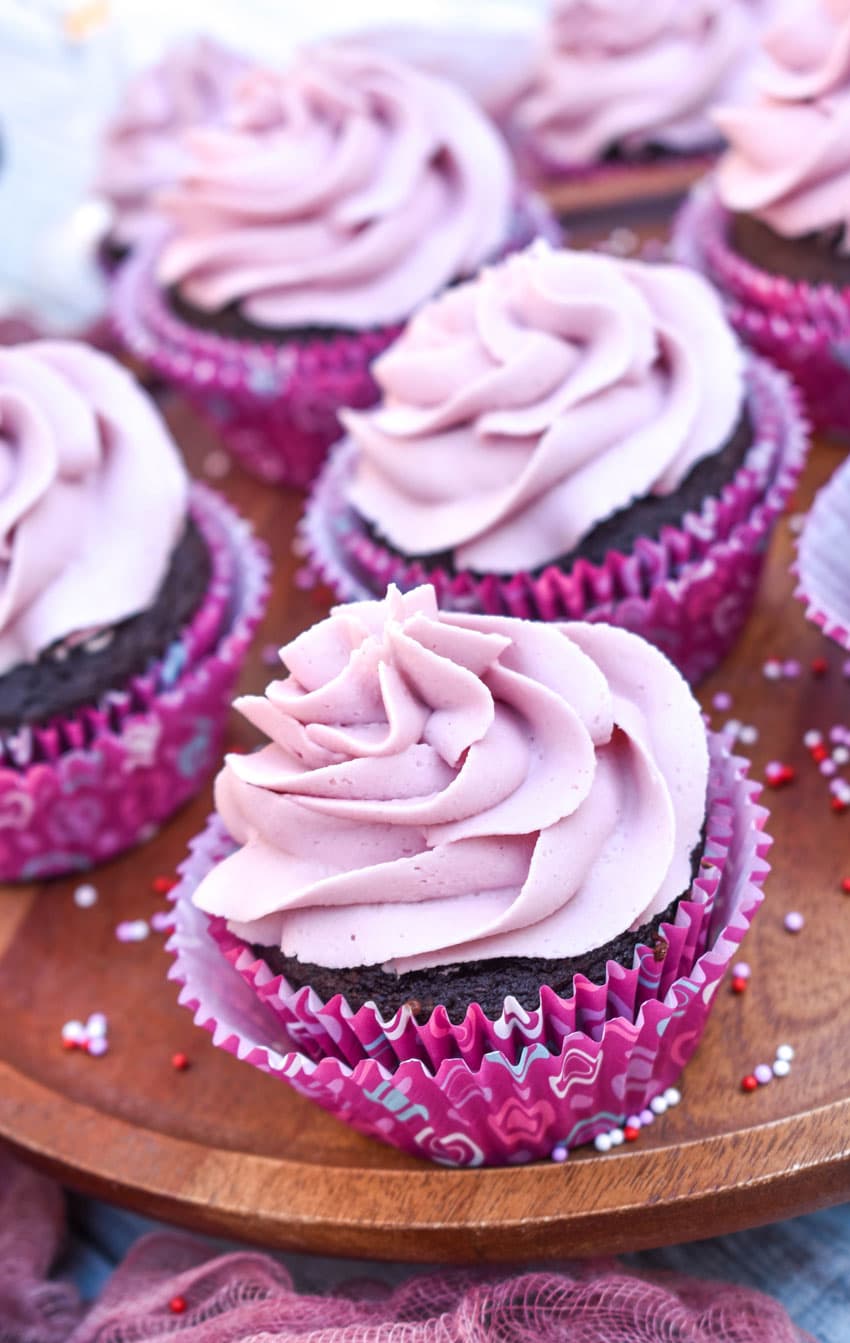 dark chocolate cupcakes with red wine buttercream frosting on a wooden cake stand