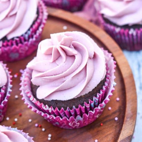 dark chocolate cupcakes with red wine buttercream frosting on a wooden cake stand