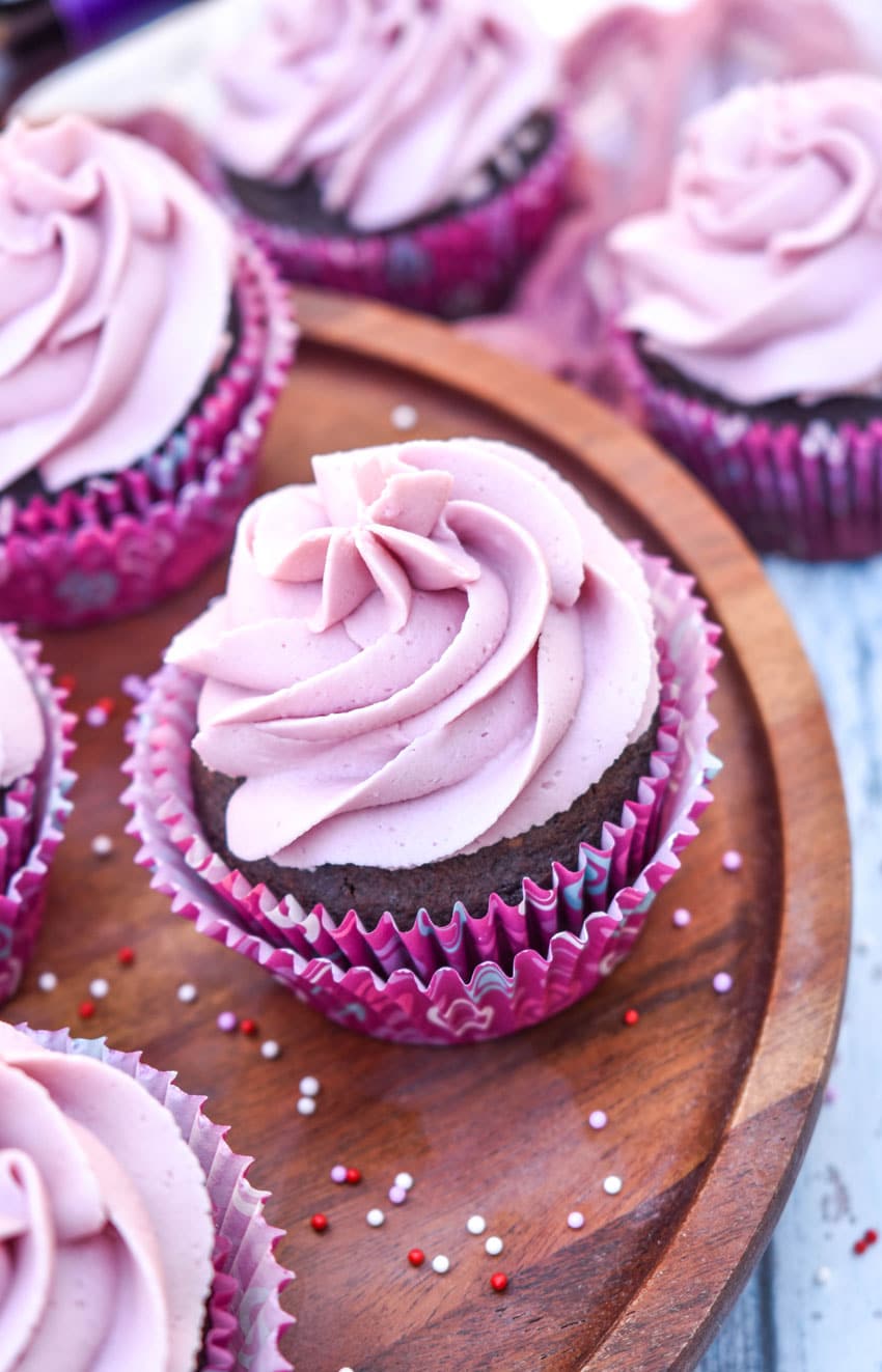 dark chocolate cupcakes with red wine buttercream frosting on a wooden cake stand